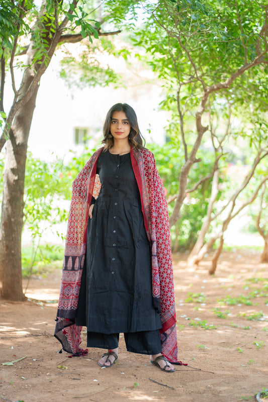 Shruti black suit set with red printed dupatta draped over both shoulders